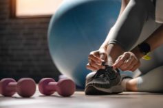 person tying shoelaces, getting ready for the gym