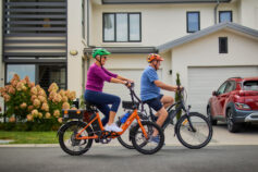 A senior woman and man riding e-bikes together