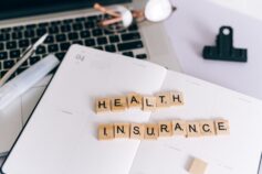 Health insurance spelled out with wooden letter tiles
