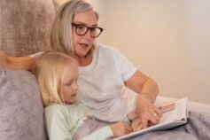 Grandmother reading a book with her young granddaughter.