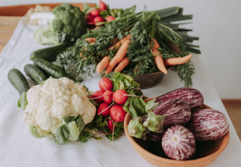 Fresh cauliflower, carrots, radishes, cucumbers and eggplants.